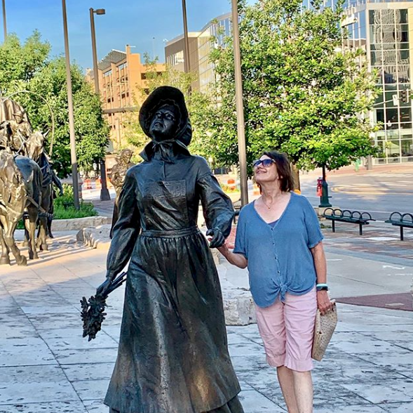 woman poses with statue