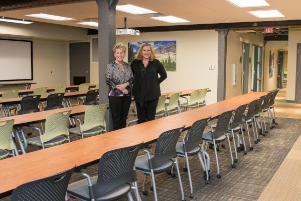 1415—The Meeting Space with Anne Minton & Lorinda Northrup standing between long conference tables